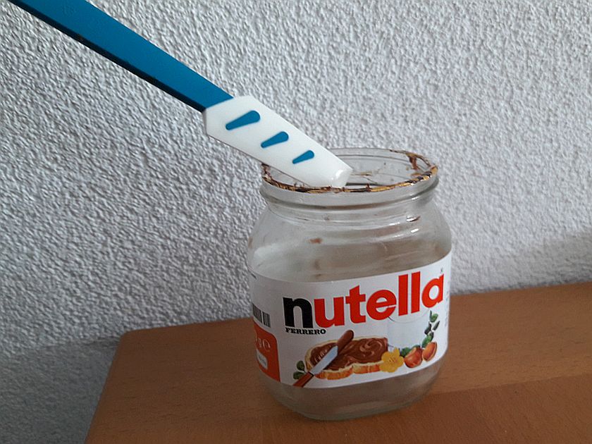 leeres nutellaglas mit gummischaber