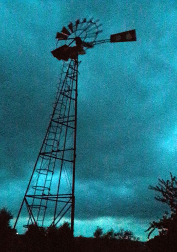 Windrad mit stürmischen Himmel im Hintergrund