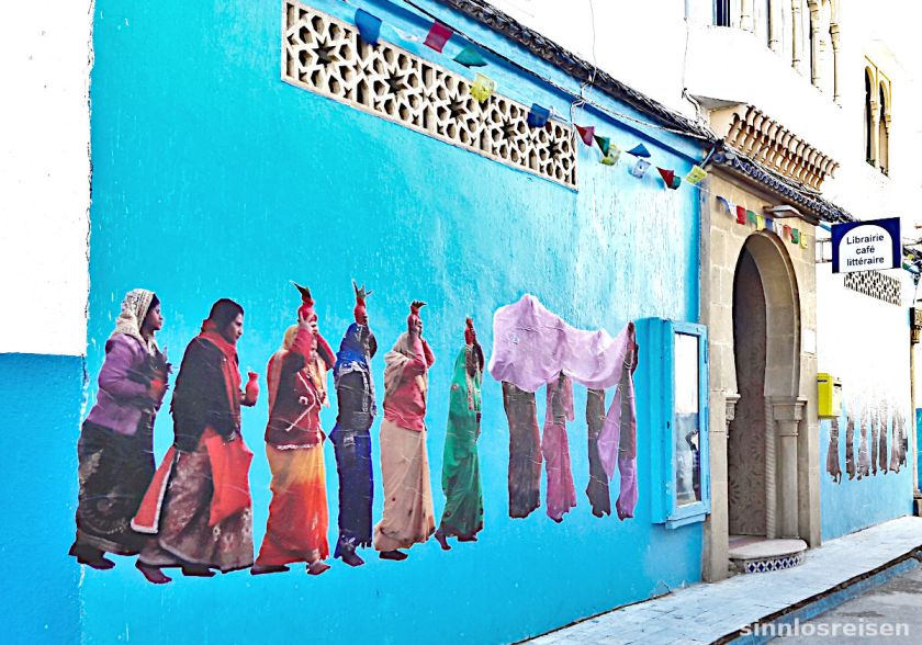 Buntgekleidete Frauen auf der Wand einer Bücherei in Marokko