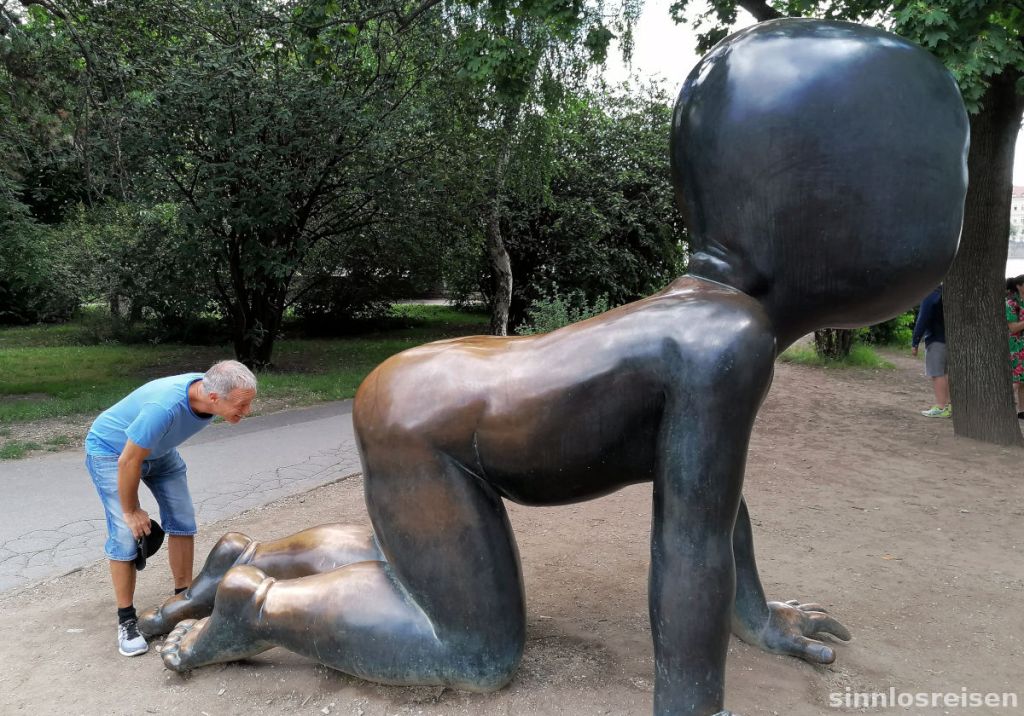 Neugieriger Tourist vor Skulptur
