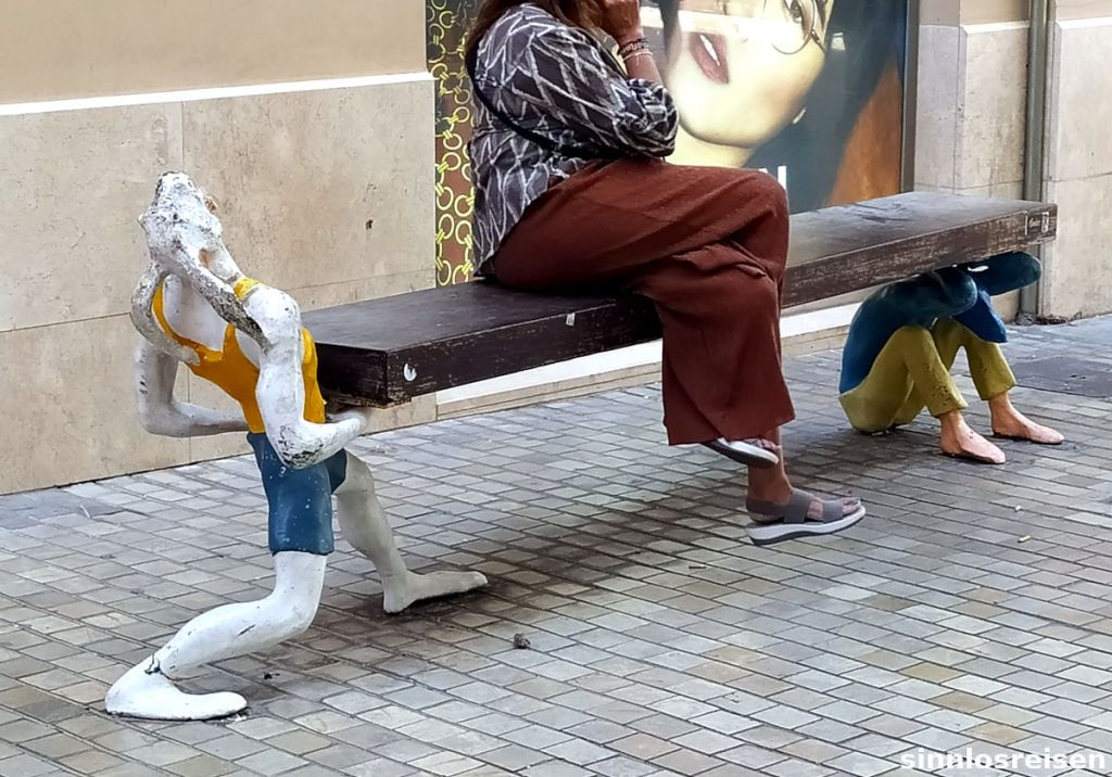 Skulpturen tragen Sitzbank