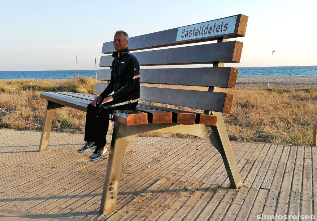 Mann sitzt auf überdimensionaler Bank