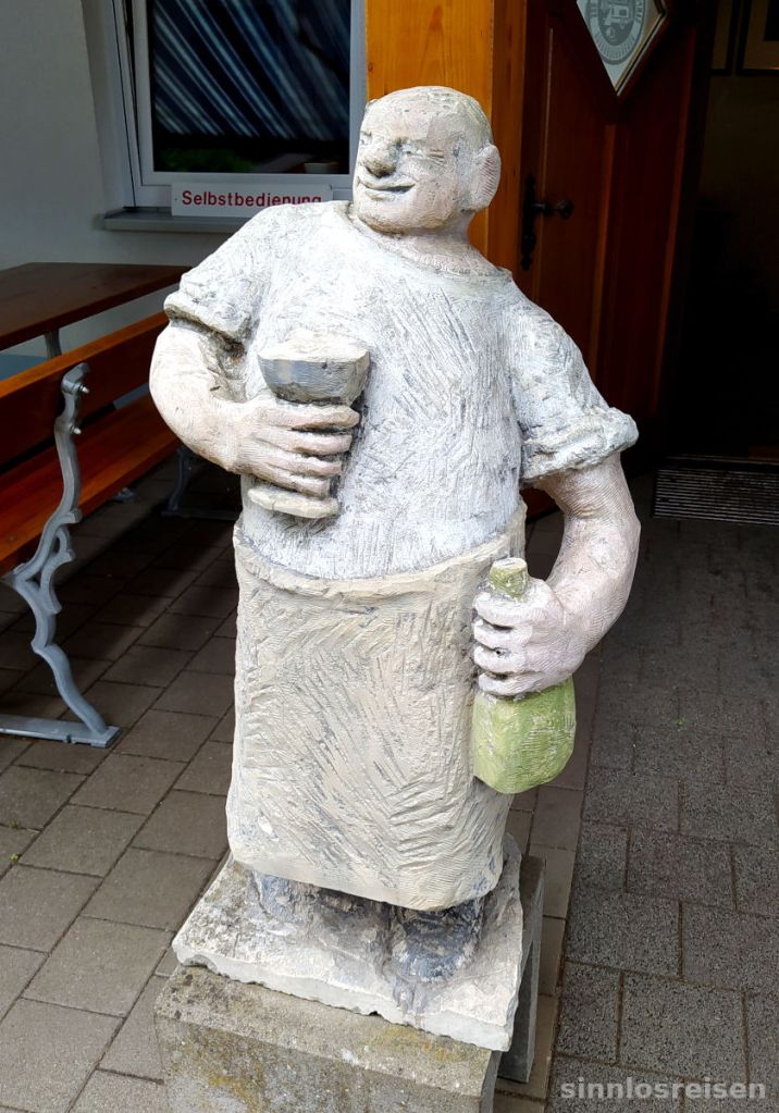 Skulptur Wirt mit Weinflasche und Trinkbecher
