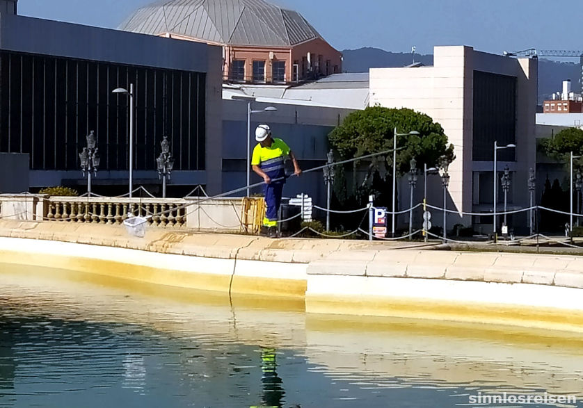 Städtischer Arbeiter reinigt den Brunnen