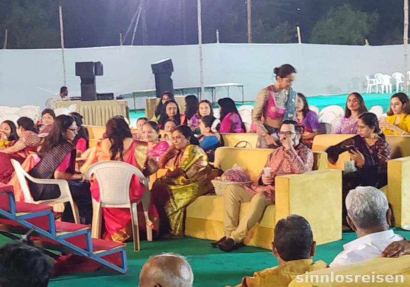 Europäischer Mann sitzt inmitten von indischen Frauen