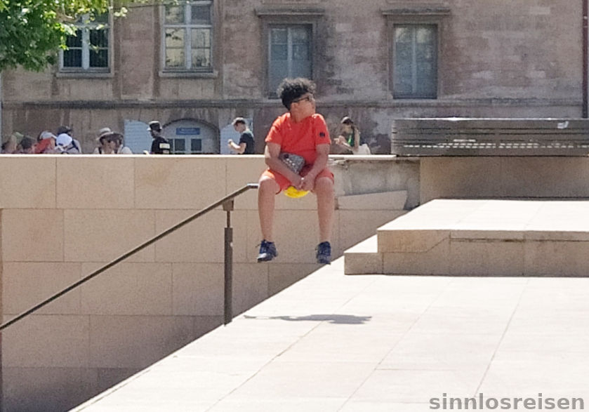 Junge sitzt auf Geländer