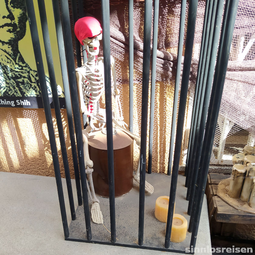 Trommelndes Skelett in Käfig