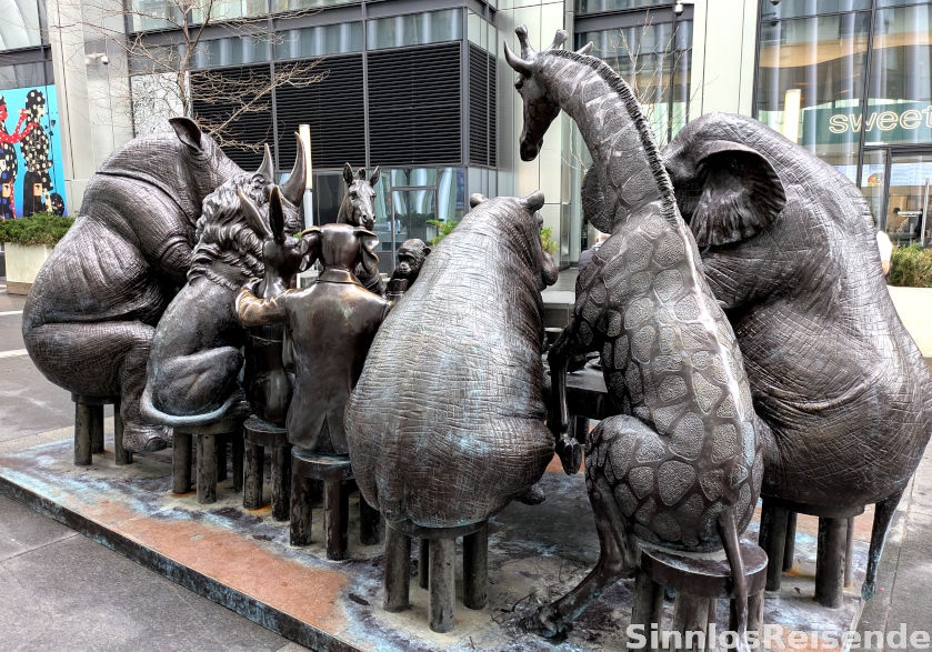 Skulptur: Tisch mit großen Tieren beim Feierabendbier