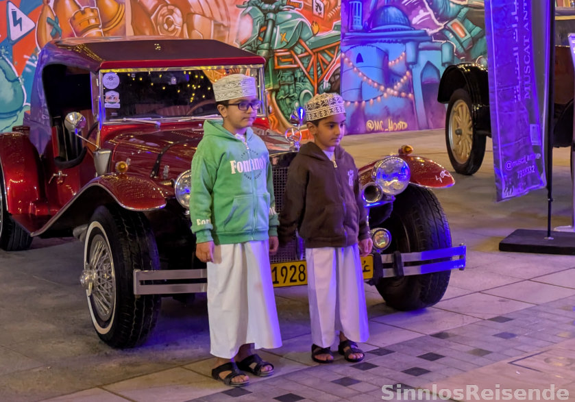 Zwei Jungs vor Oldtimern